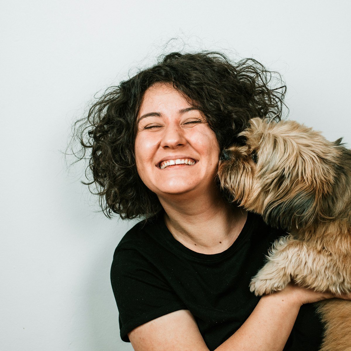 Une femme souriante serre son chien contre elle